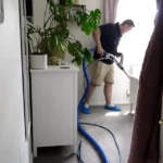 DustBlasters cleaning a living room carpet with professional extraction equipment in a Peterborough home