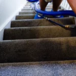 Carpeted stairs being deep cleaned with a hot water extraction wand by DustBlasters in Peterborough